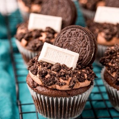 Close up of Oreo Cupcakes on a wire rack on a blue napkin.