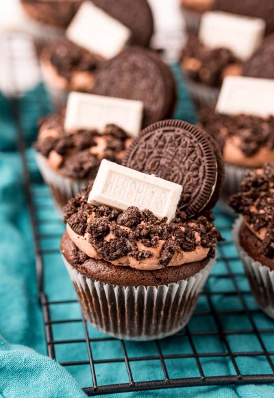 Close up of Oreo Cupcakes on a wire rack on a blue napkin.