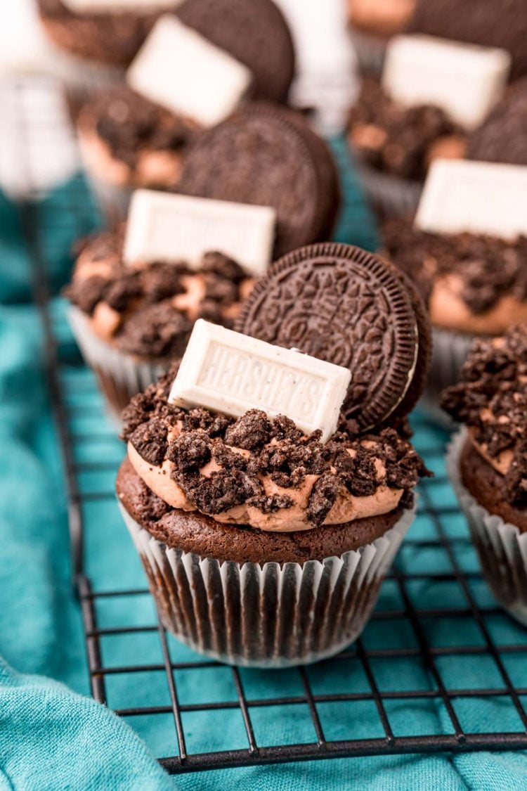 Close up of Oreo Cupcakes on a wire rack on a blue napkin.