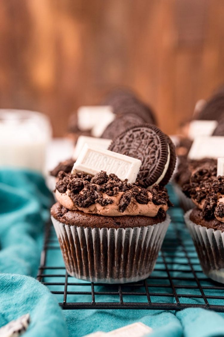 Close up of Oreo Cupcakes on a wire rack on a blue napkin.