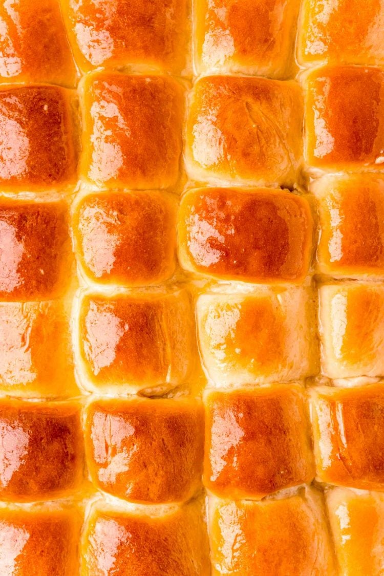 Overhead photo of a pan of dinner rolls that have been brushed with butter.