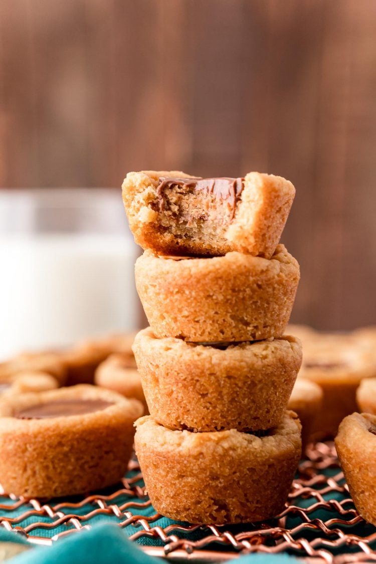 Close up photo of four peanut butter cookie bites stacked on top of each other and the top one is missing a bite.