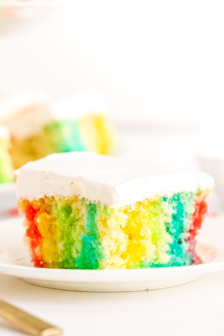 This Rainbow Jello Poke Cake is easily made using a boxed white cake mix and jello to create a fun, light dessert filled with vibrant colors!