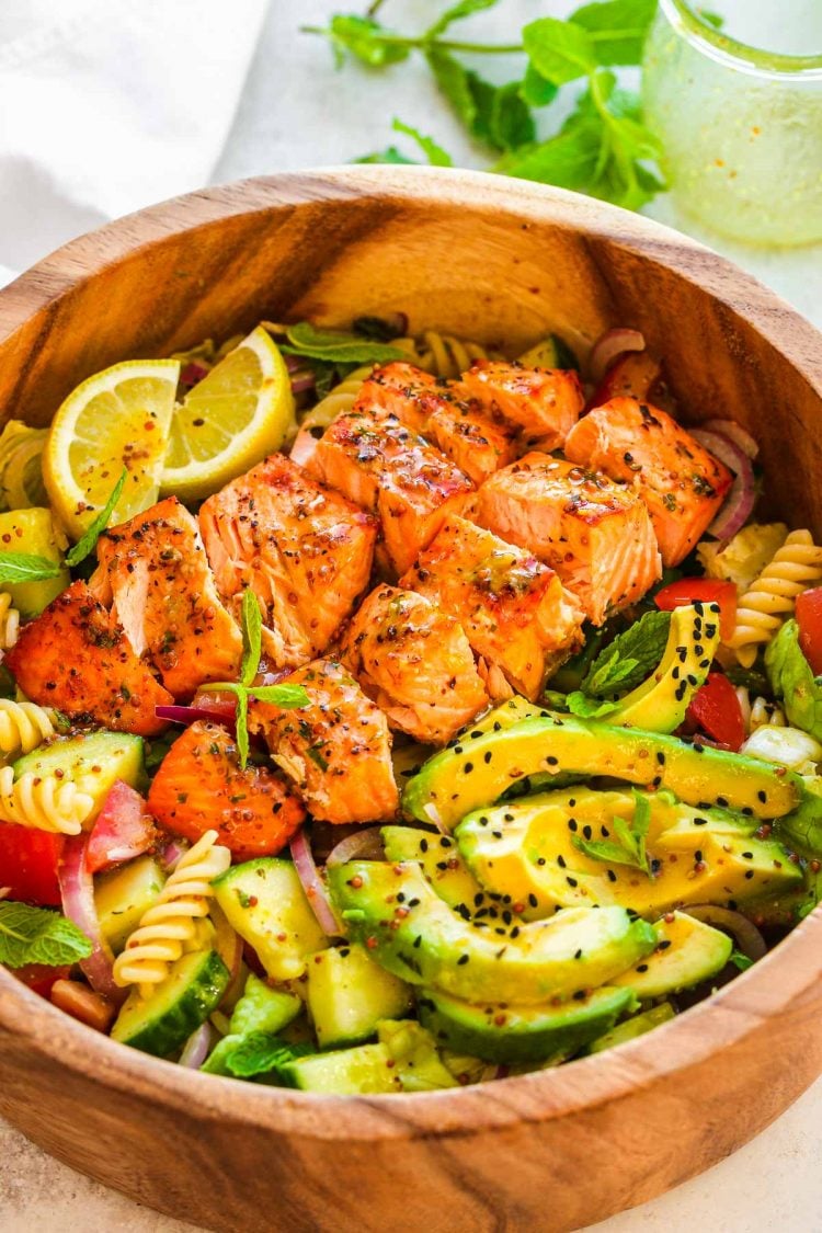 Salmon pasta salad in a wooden serving bowl.