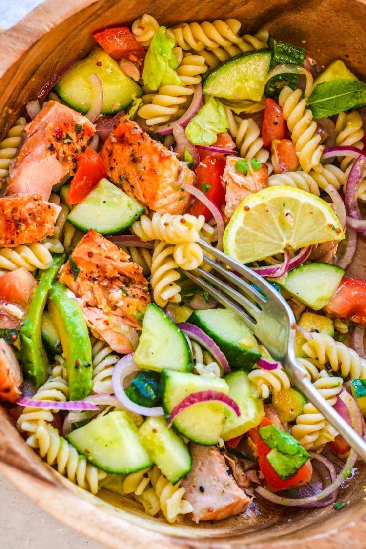 Overhead photo of a wooden serving bowl with salmon pasta salad in it.