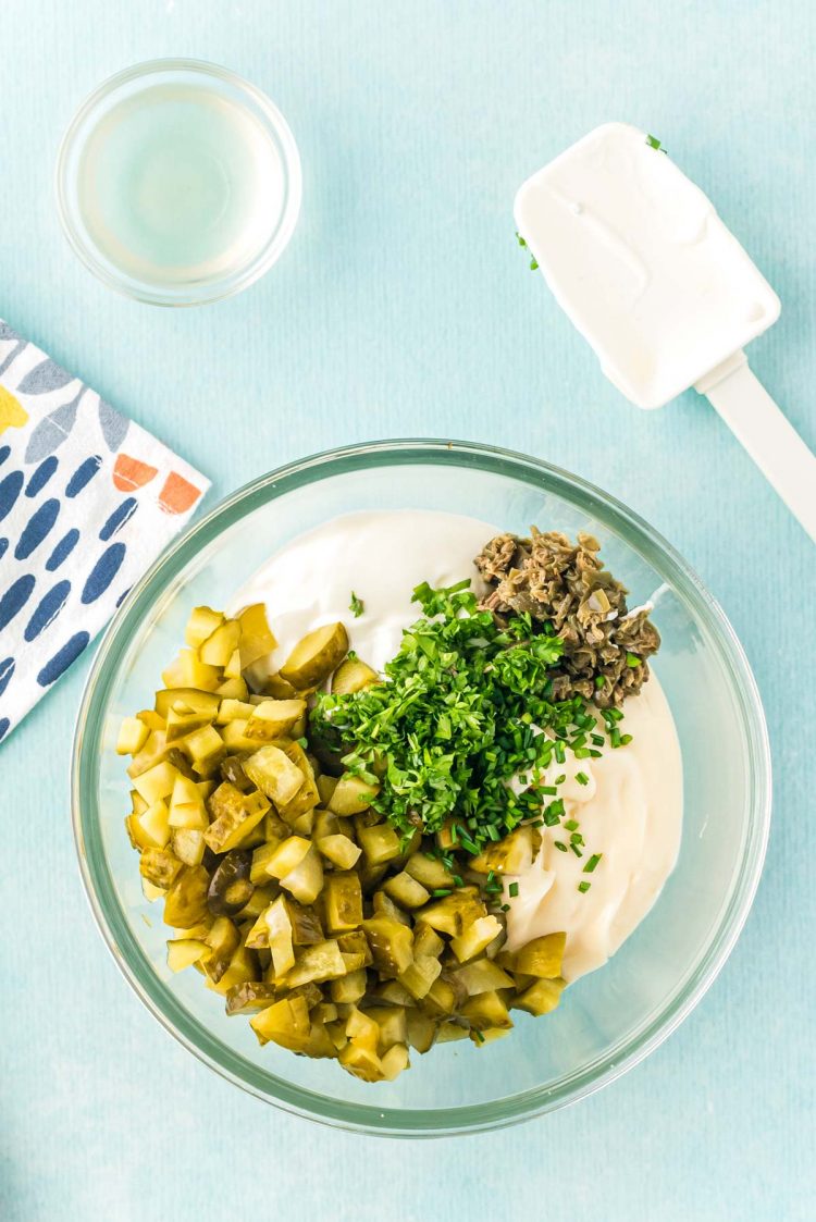 Overhead photo of ingredients to make tartar sauce in a glass bowl.