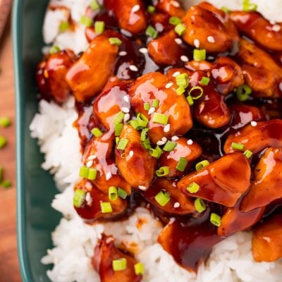 Bourbon Chicken plated on rice with green onion garnish