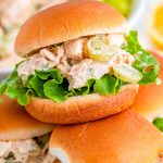 Close up photo of burger burns with chicken salad piled on a plate.