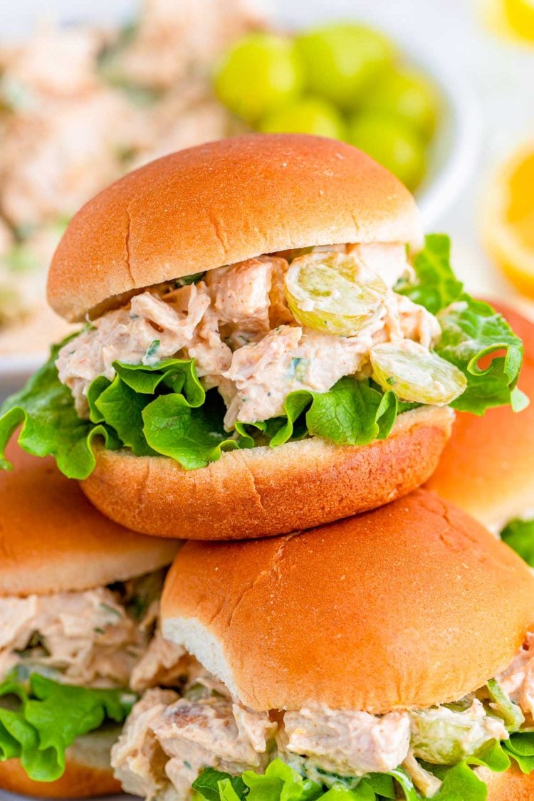 Close up photo of burger burns with chicken salad piled on a plate.