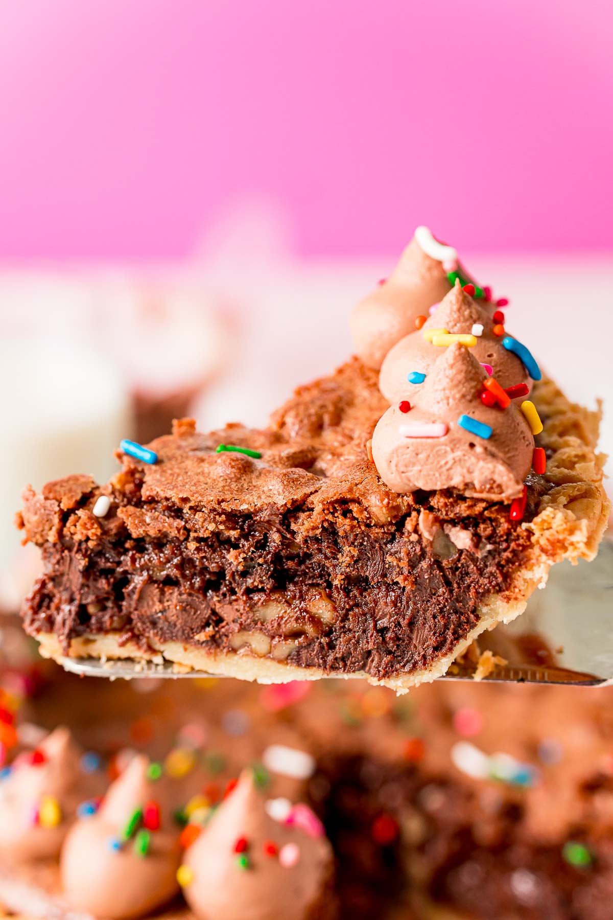 Close up photo of a slice of chocolate toll house pie on a pie server.