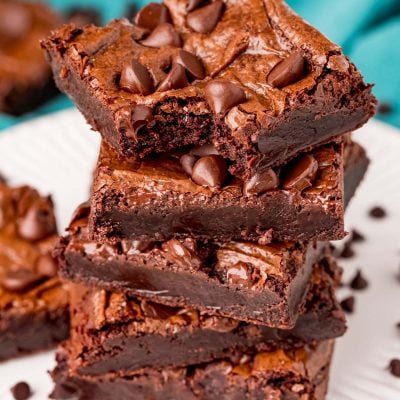 close up photo of a stack of brownies with the top one missing a bite.