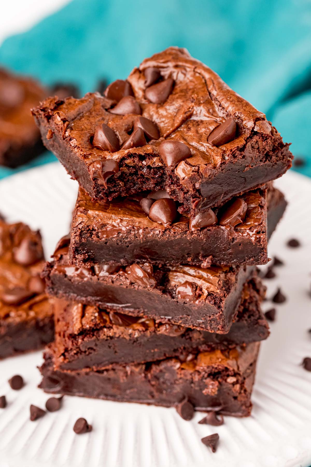 close up photo of a stack of brownies with the top one missing a bite.