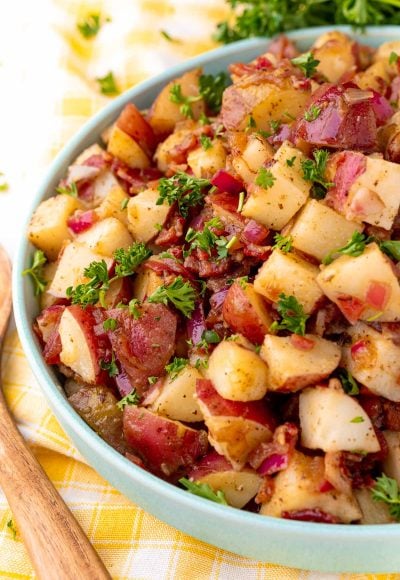 Close up photo of a teal bowl with German potato salad in it.