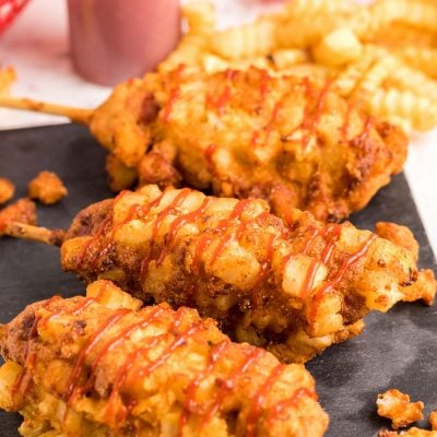 Close up photo of Korean corndogs on a slate board.