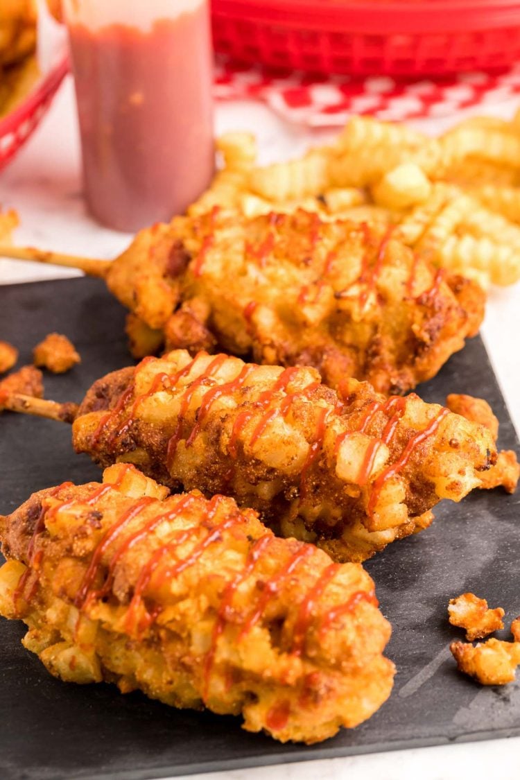 Close up photo of Korean corndogs on a slate board.