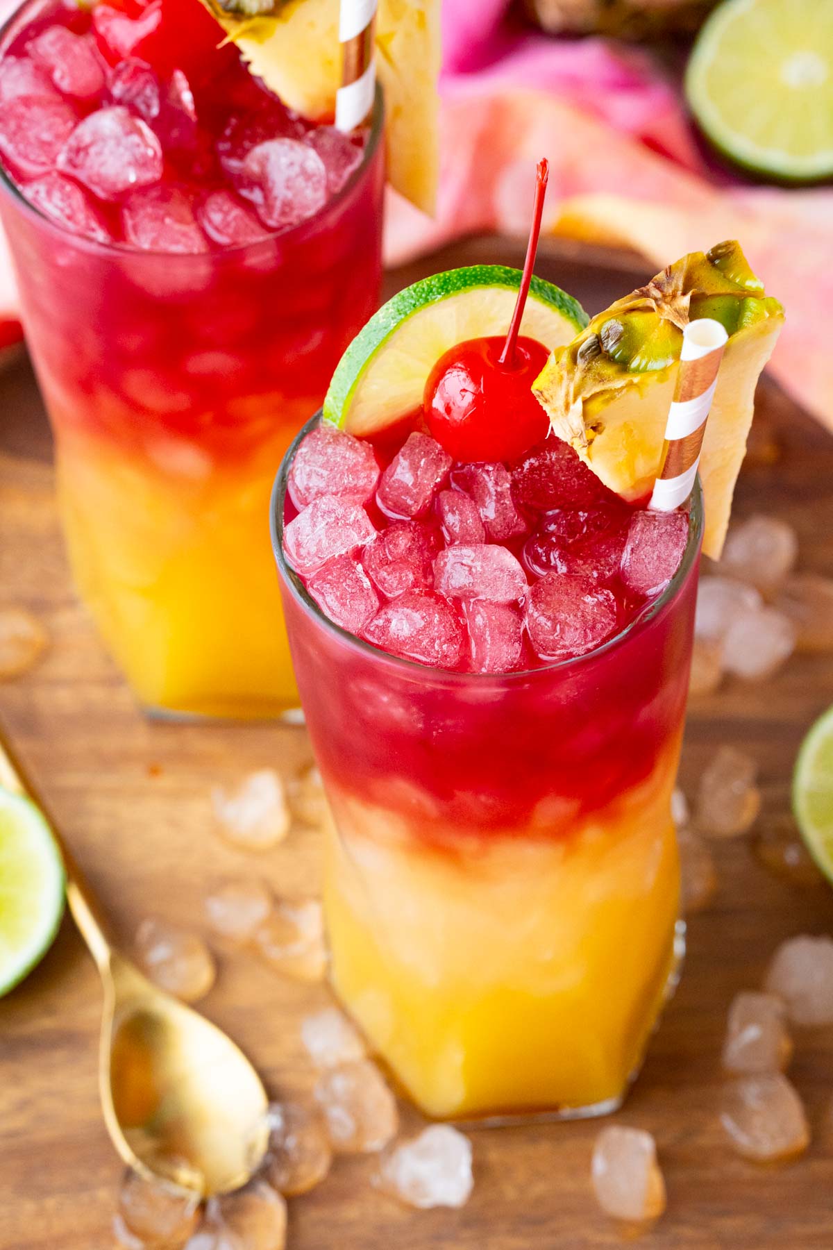 Close up photo of a Malibu Bay Breeze drink garnished with pineapple, cherry, and lime.