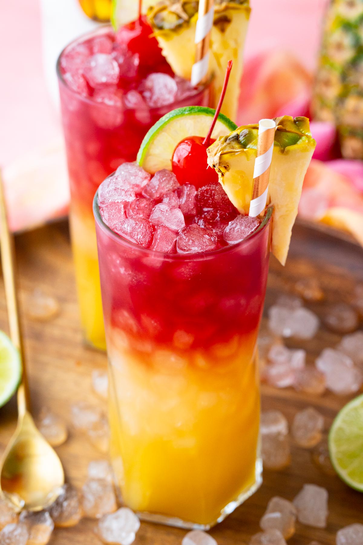 Close up photo of a Malibu Bay Breeze drink garnished with pineapple, cherry, and lime.