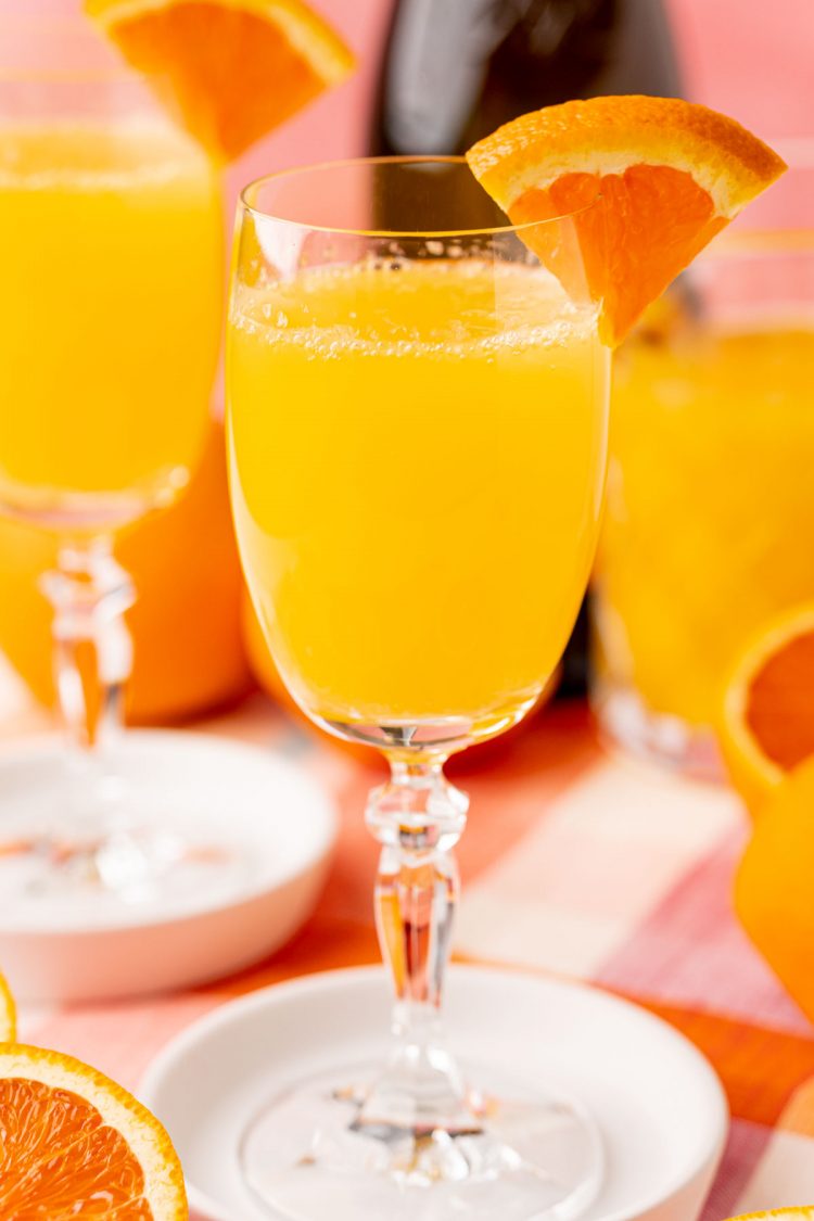 Close up of a mimosa garnished with orange.