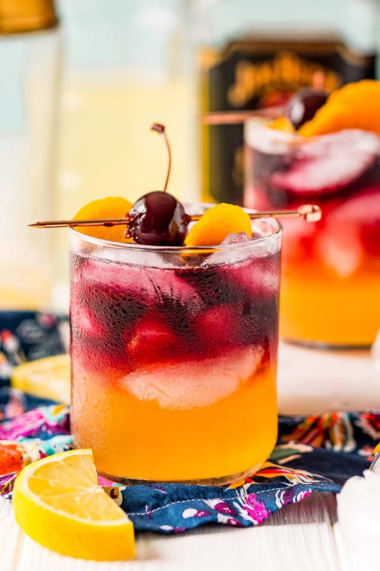 Close up photo of a New York Sour Cocktail on a blue napkin with a lemon next to it.