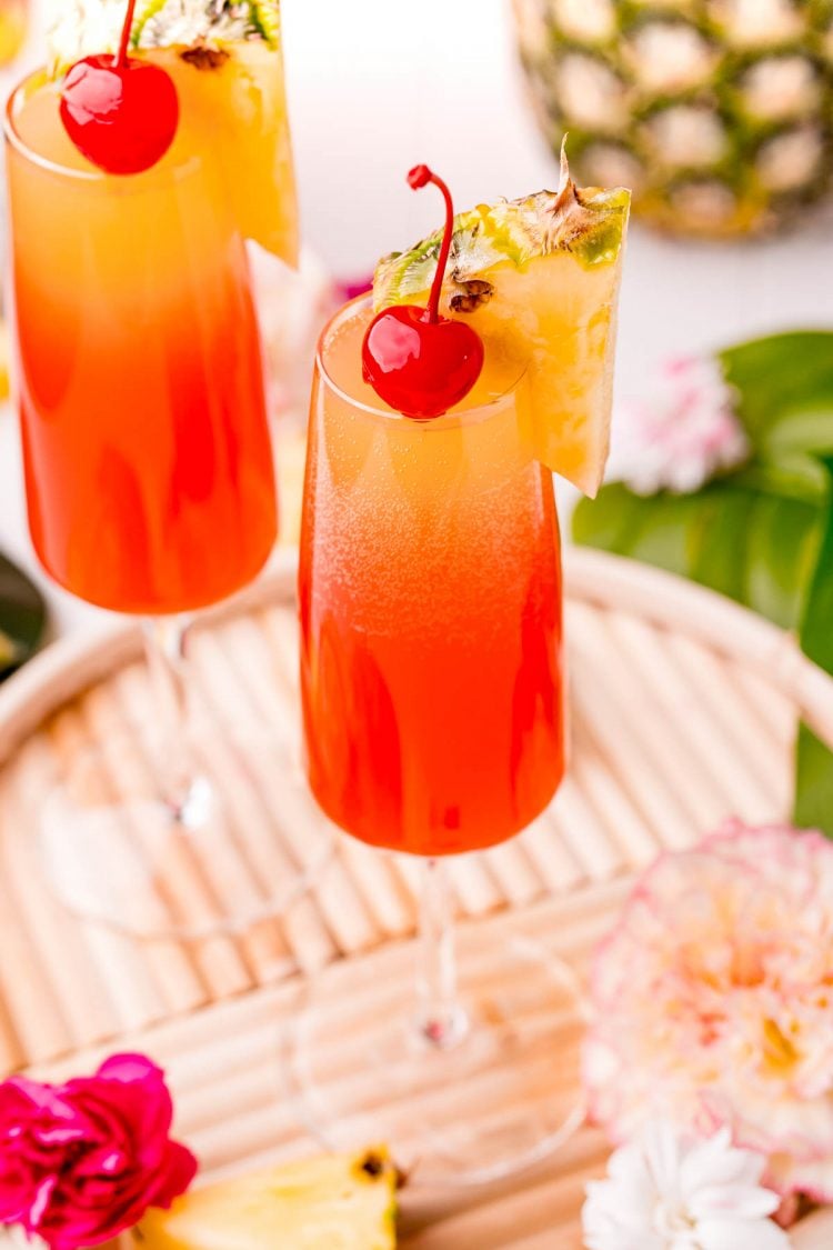 Close up photo of a Hawaiian Mimosa garnished with a maraschino cherry and pineapple wedge.