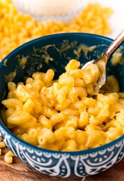 Close up photo of mac and cheese in a teal mug.