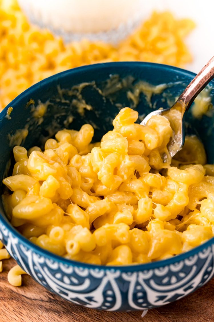 Close up photo of mac and cheese in a teal mug.