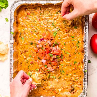 Hands dipping tortilla chips into tiktok smoked queso.