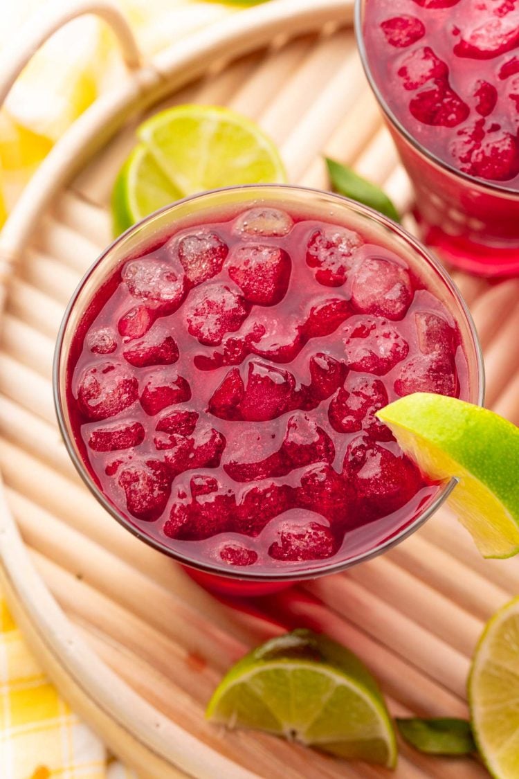 Close up photo of a woo woo cocktail garnished with lime on a wooden tray.