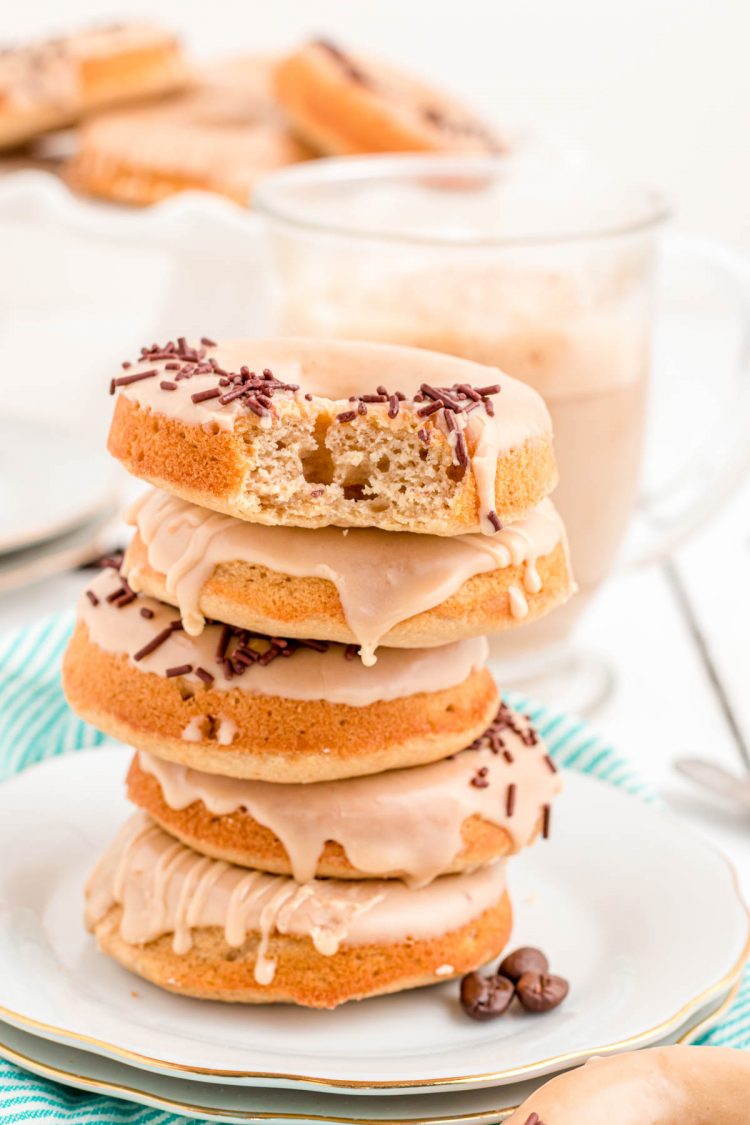 Photo of a stack of 5 coffee donuts on a white plate.