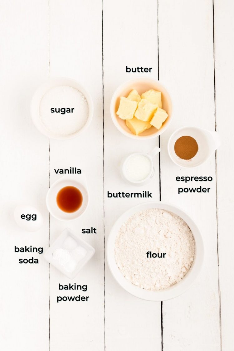 Overhead photo of ingredients prepped to make coffee donuts on a white wooden table.