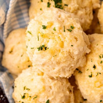 Close up photo of classic drop biscuits in a basket with a blue linen napkin.