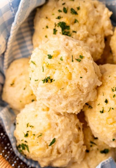 Close up photo of classic drop biscuits in a basket with a blue linen napkin.