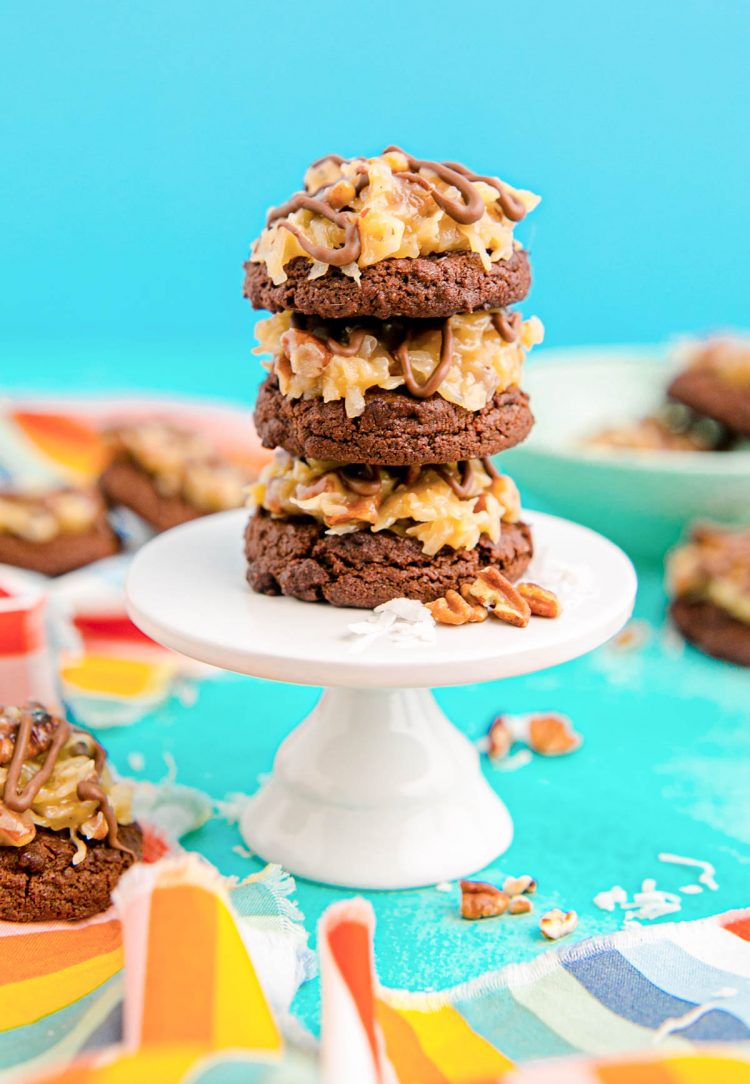 German Chocolate Cookies stacked on a small white cake stand.