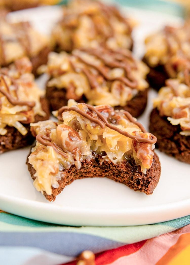 German Chocolate Cookies on a white plate with a bite taken out of one.