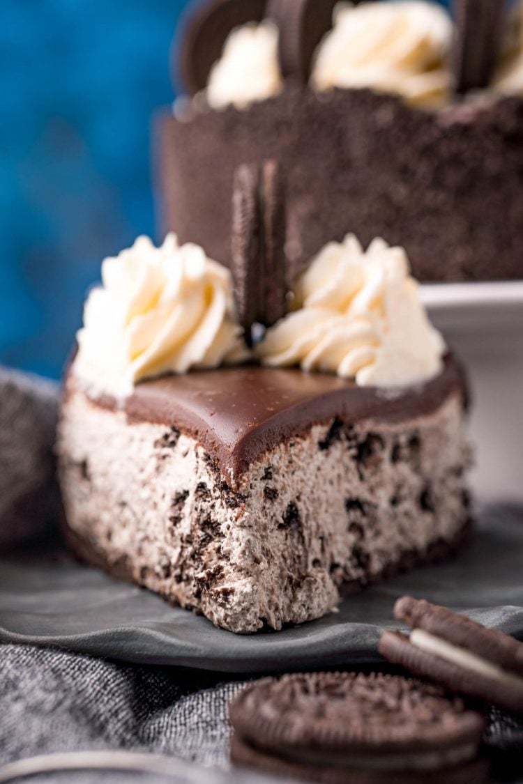 Straight on photo of a piece of oreo no bake cheesecake on a gray plate with oreos around it.