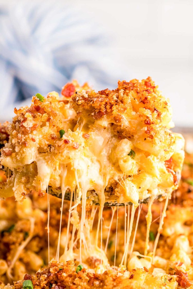 Close up photo of a serving spoon scooping mac and cheese out of a pan.