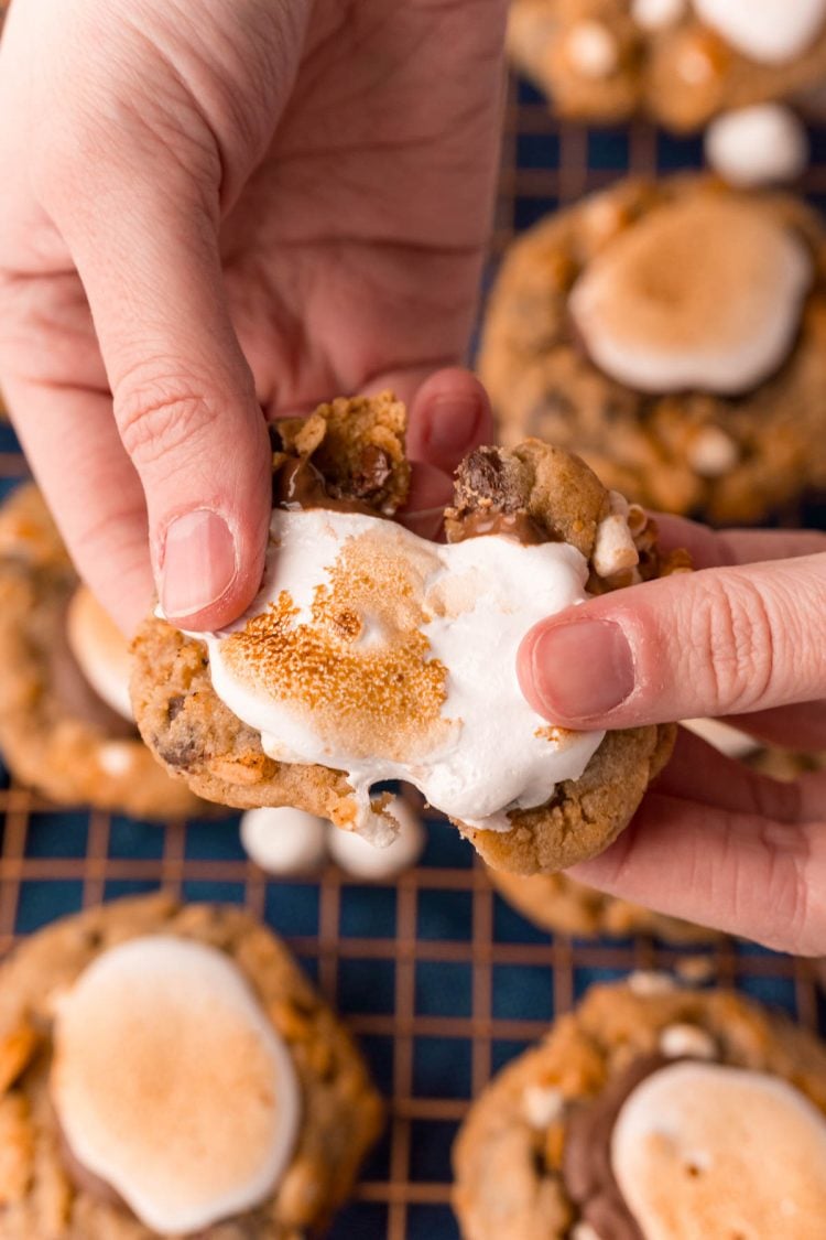 A woman's hand pulling a s'mores cookie apart.