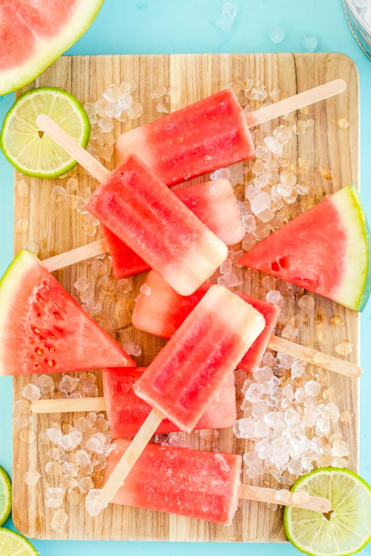 overhead photo of watermelon popsicles on a wooden cutting board.