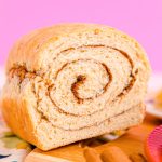 Close up photo of a loaf of cinnamon swirl bread that has been sliced into revealing the center.