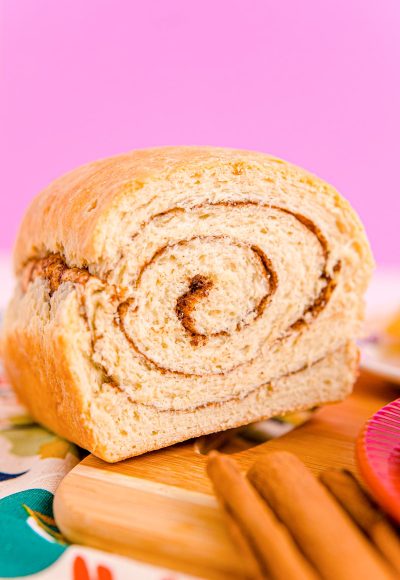 Close up photo of a loaf of cinnamon swirl bread that has been sliced into revealing the center.