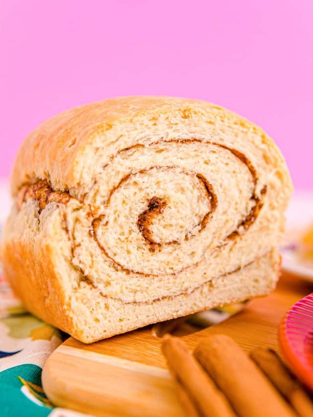 Close up photo of a loaf of cinnamon swirl bread that has been sliced into revealing the center.
