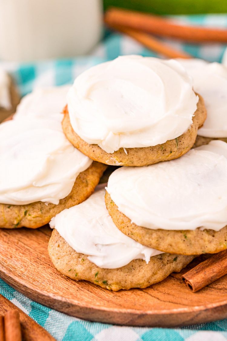 Close up photo of frosted zucchini cookies on a wooden plate. 