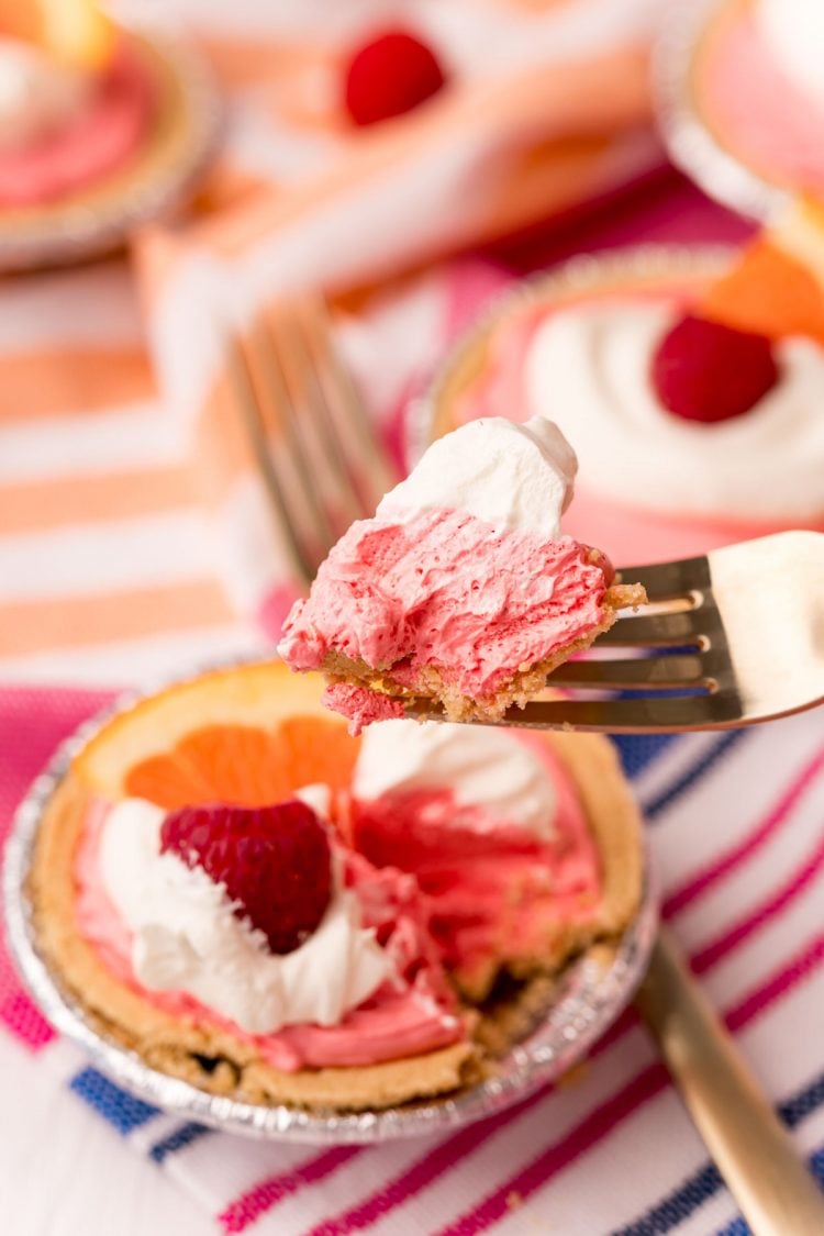 A fork with a bite of kool-aid pie on it being held to the camera.