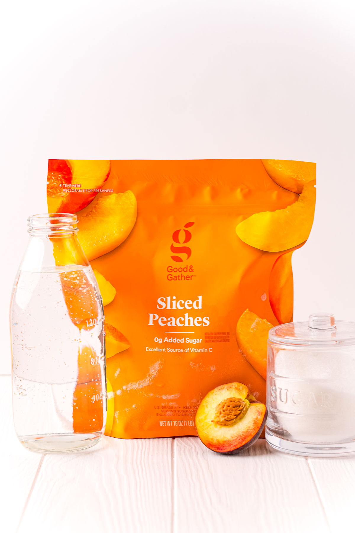 Ingredients used to make peach simple syrup on a white backdrop.