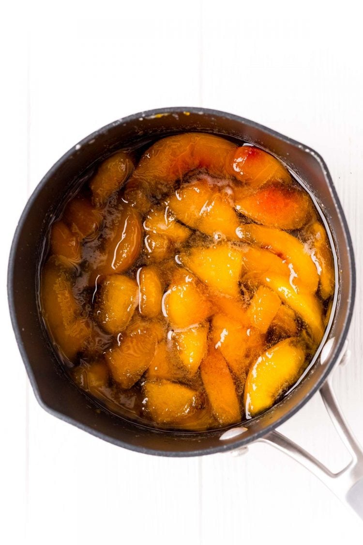 Overhead photo of peach simple syrup being made in a saucepan.