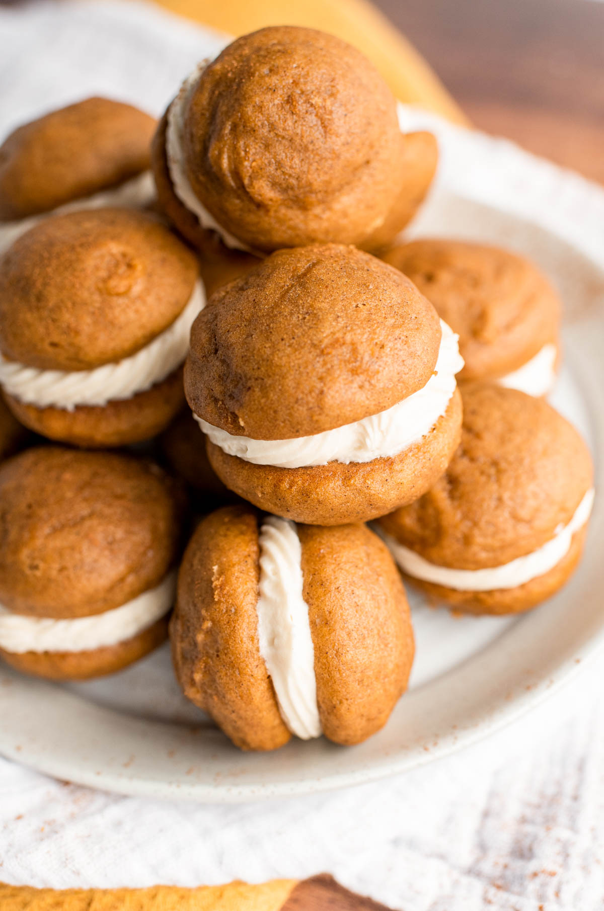 A white plate filled with mini pumpkin whoopie pies.