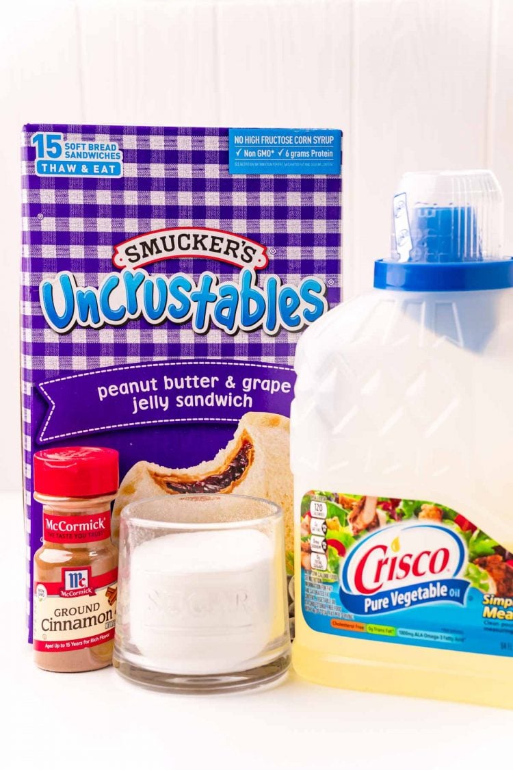 Ingredients to make uncrustables donuts on a white table.