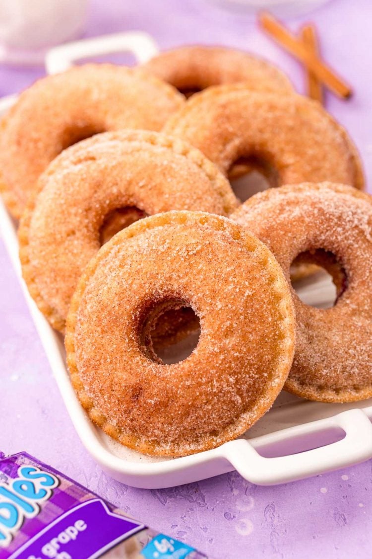 Close up photo of uncrustables donuts on a white serving tray on a purple surface.