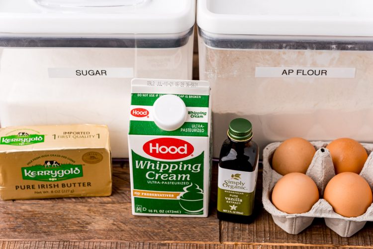 Photo of ingredients to make whipped cream cake on a wooden table.