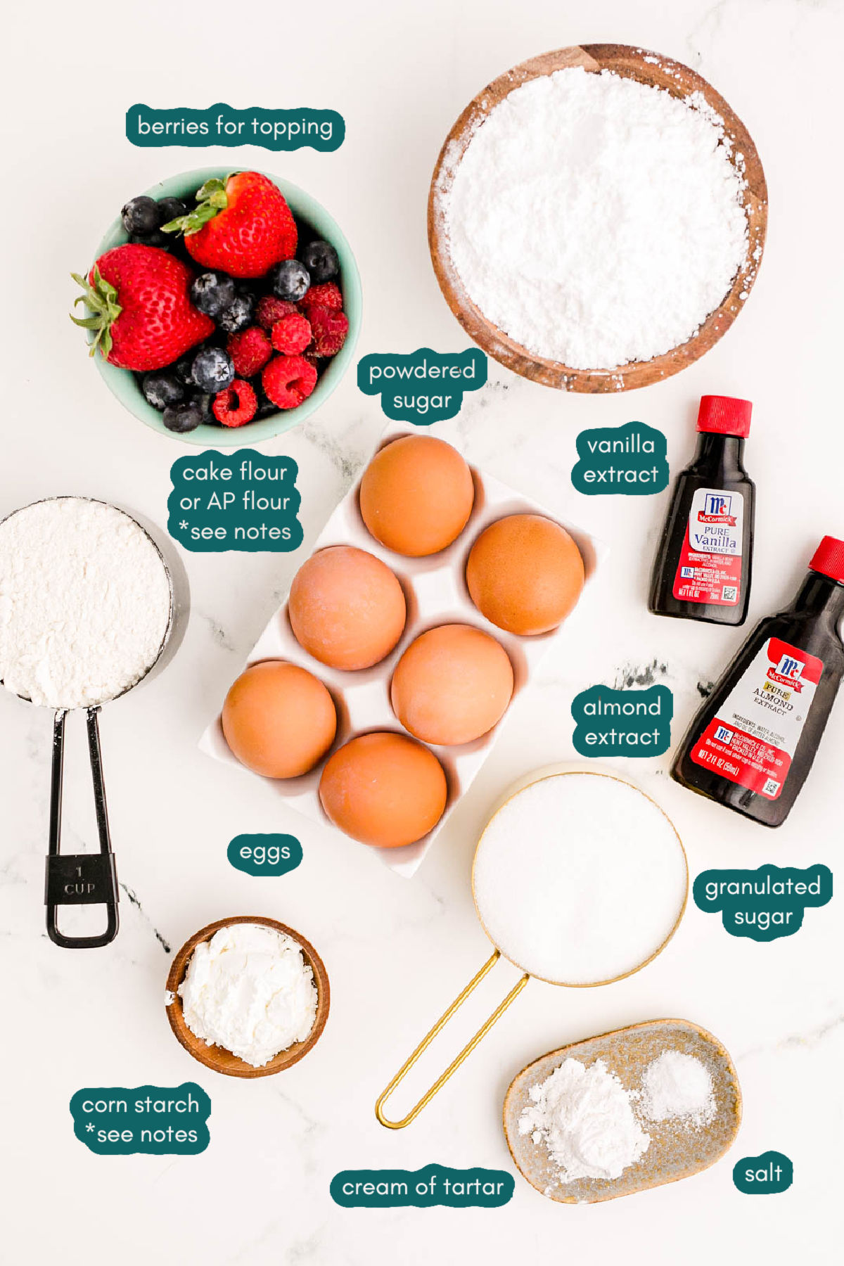 Ingredients to make angel food cake from scratch on a marble counter.